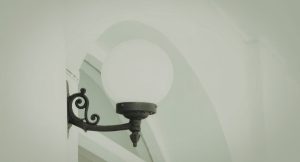 Lampe d'exterieur noire avec un globe en verre installee sur un mur de batiment