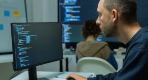 Developpeur informatique ecrivant des lignes de code sur l'ecran de son ordinateur