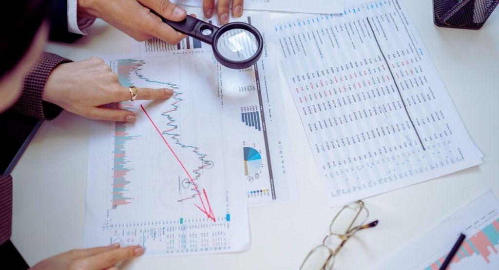 Plusieurs personnes analysant ensemble des graphiques et donnees disposes sur une table