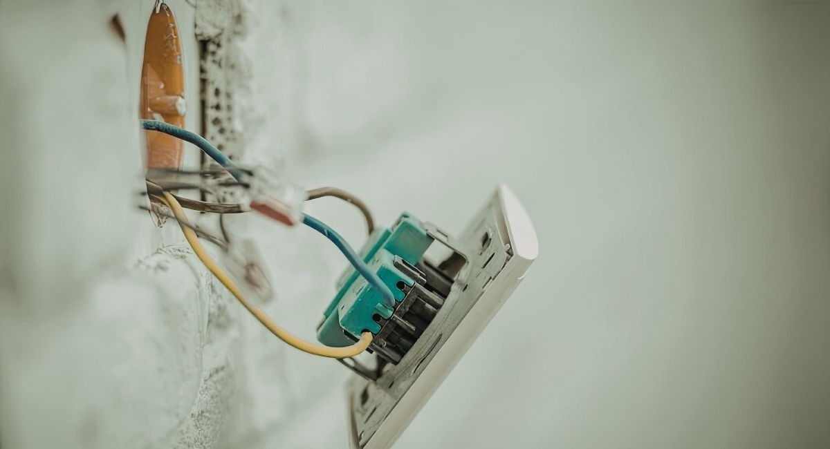 Interrupteur mural ouvert montrant les fils electriques dans la boite d encastrement