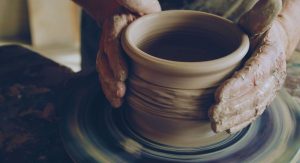 Mains de potier modelant un pot en argile sur un tour traditionnel