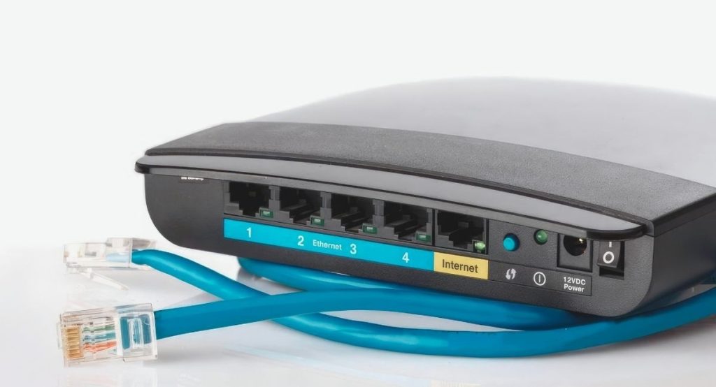 Gros plan d'un routeur internet avec un cable ethernet bleu branche sur le port WAN