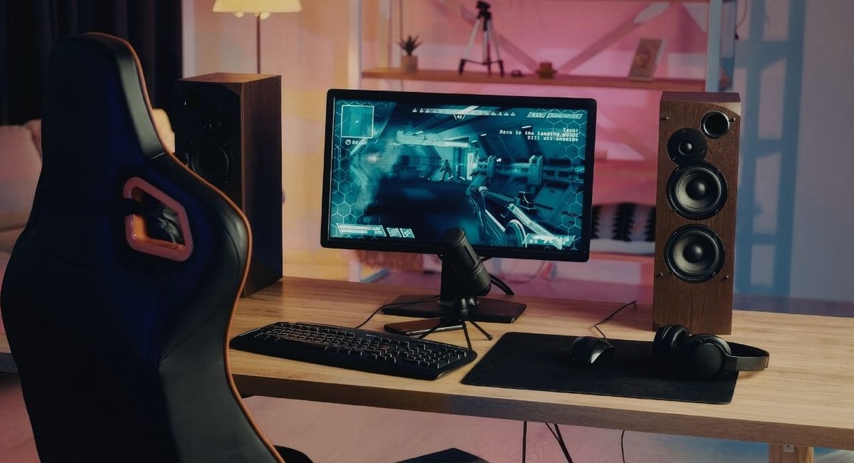 Bureau gaming avec ordinateur affichant un decor sci-fi futuriste sur l'ecran