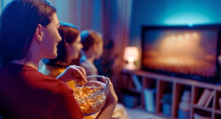 Soiree film a la maison avec un saladier de popcorn devant la television